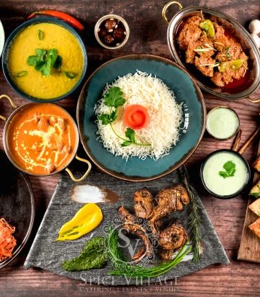 A shared spread of curries, rice, raita and grilled starters.